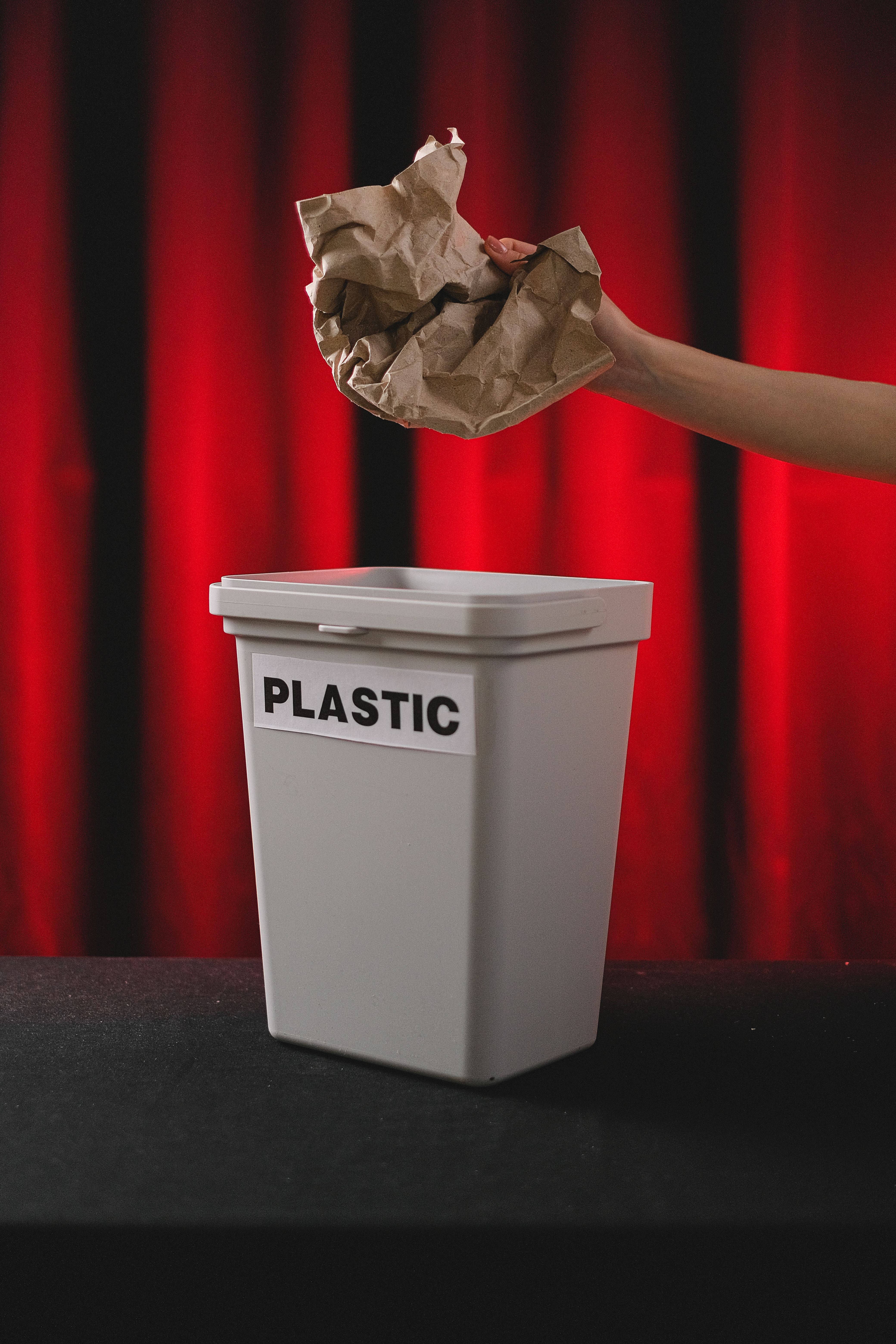 Crumpled paper being thrown into a plastic bin — a visual metaphor for misclassified evidence in drug development